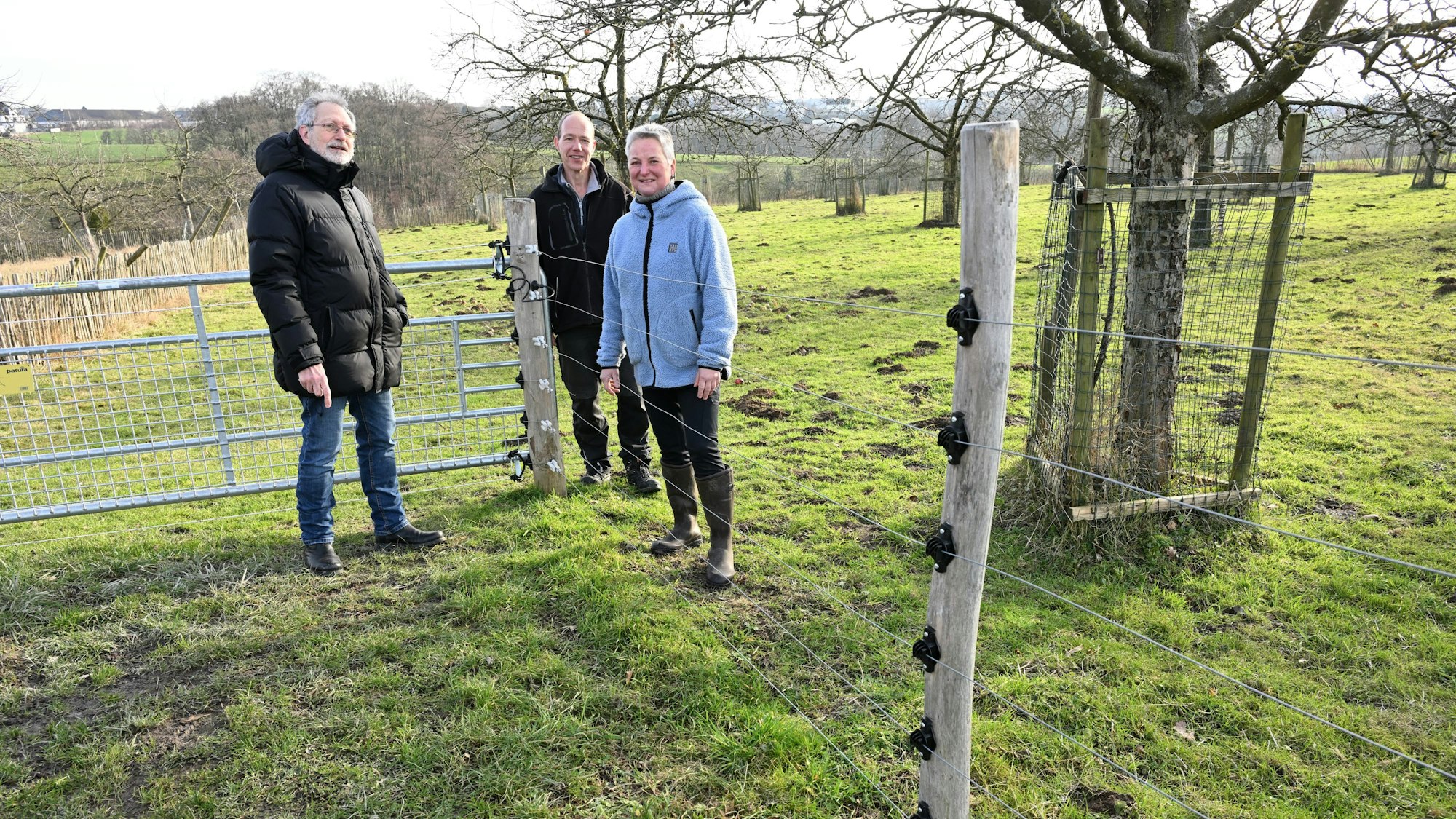 Menschen stehen an einem Wolfsschutzzaun in Kürten-Bechen.