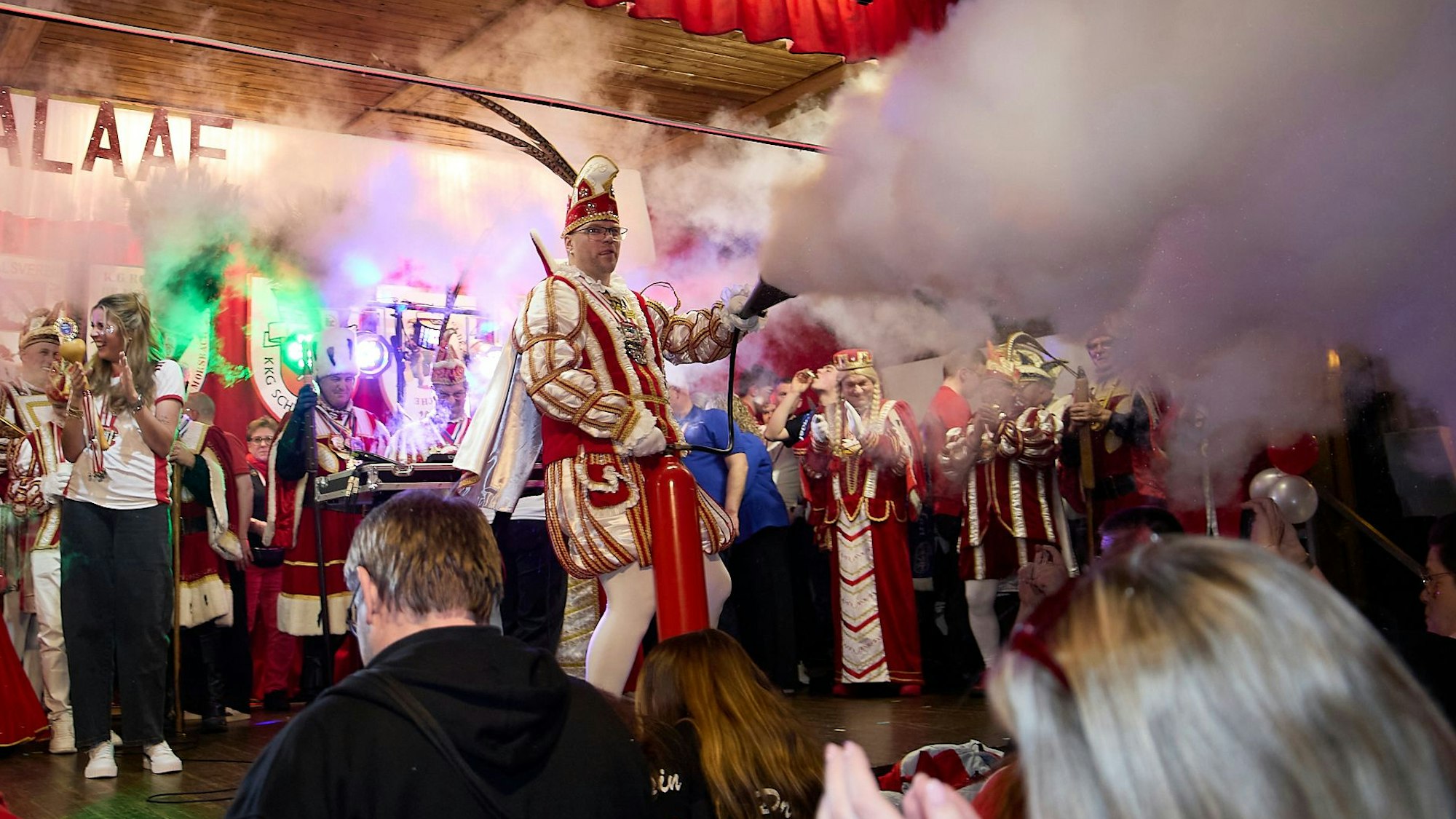 Das Bild zeigt die Vussemer Tollität auf der Bühe. Er versprüht gerade Nebel.