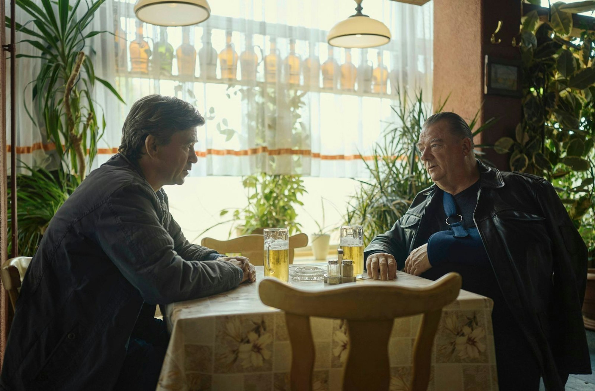 Michael Lehmann (Peter Schneider) und Henry Koitzsch (Peter Kurth) diskutieren Leben und Fall in einer Kneipe, in der die DDR nie untergegangen zu sein scheint. (Bild: MDR/Felix Abraham)