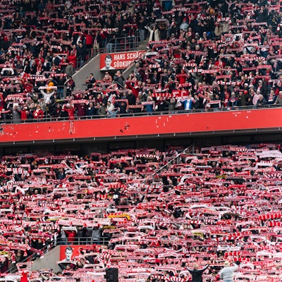 Kölner Fans halten ihre Schals beim Singen der Vereinshymne.