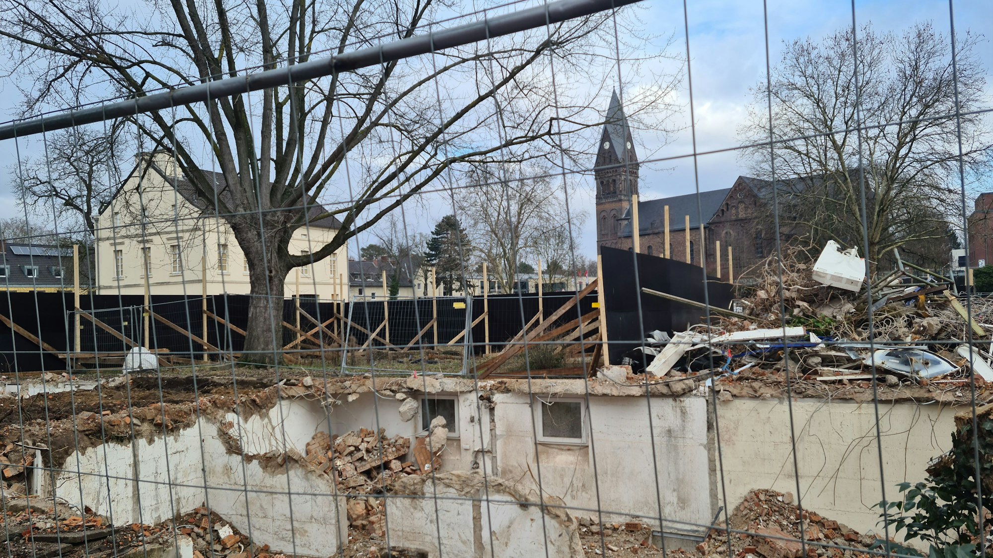 Blick auf eine Baustelle, dahinter ist eine Kirche.