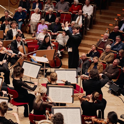 Ein Mann dirigiert ein Orchester.