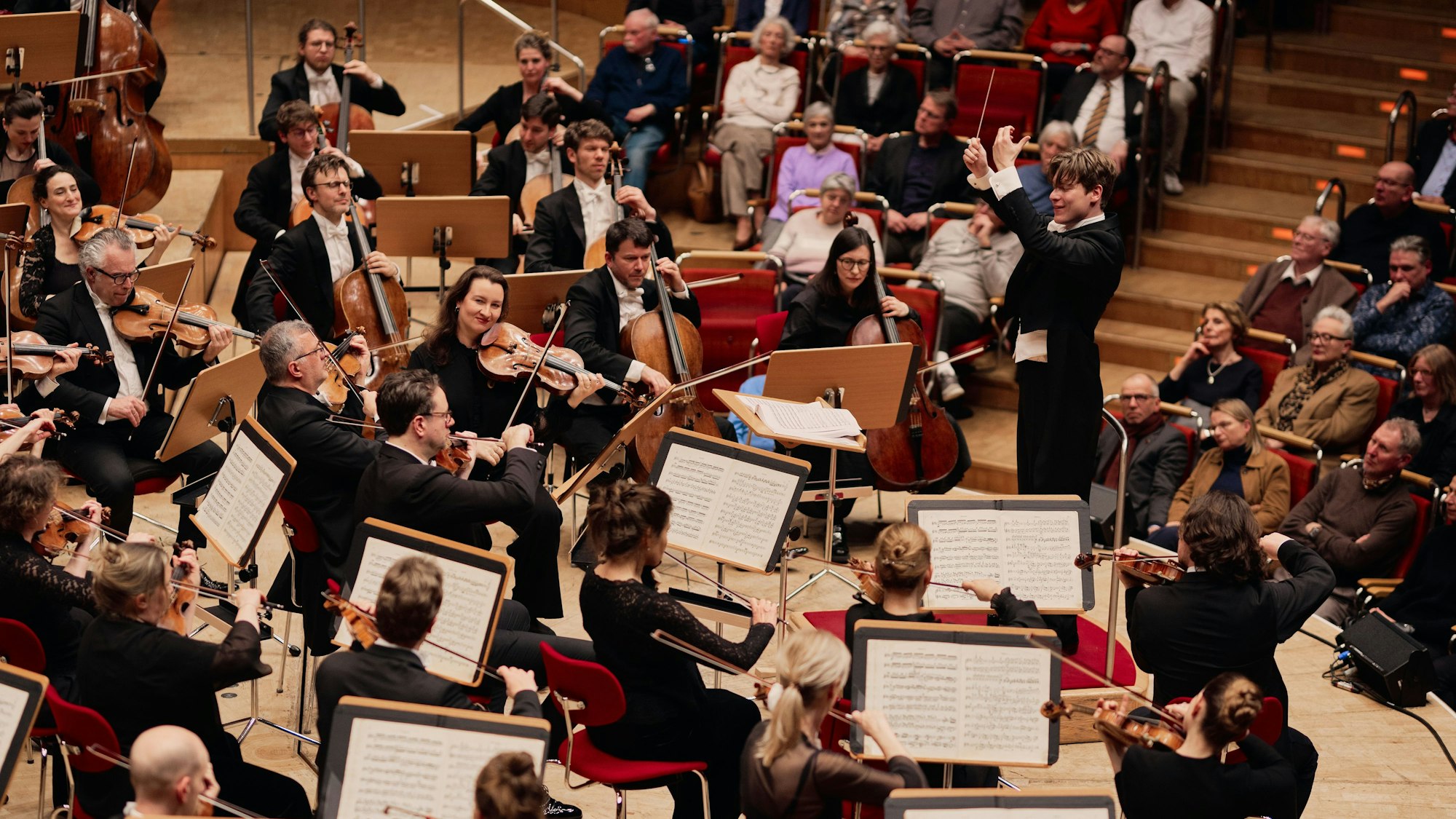 Ein Mann dirigiert ein Orchester.