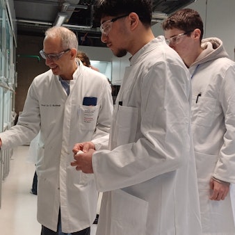 Prof. Dr. Dirk Burdinski zeigt den fluoreszierenden Farbstoff, den zwei Teilnehmer synthetisiert haben.