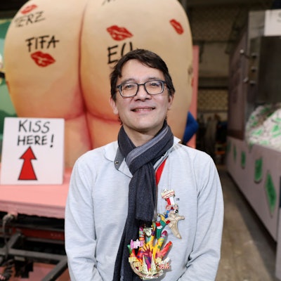 Zeichner Heiko Sakurai vor seinem Entwurf zum Trump-Karnevalswagen.