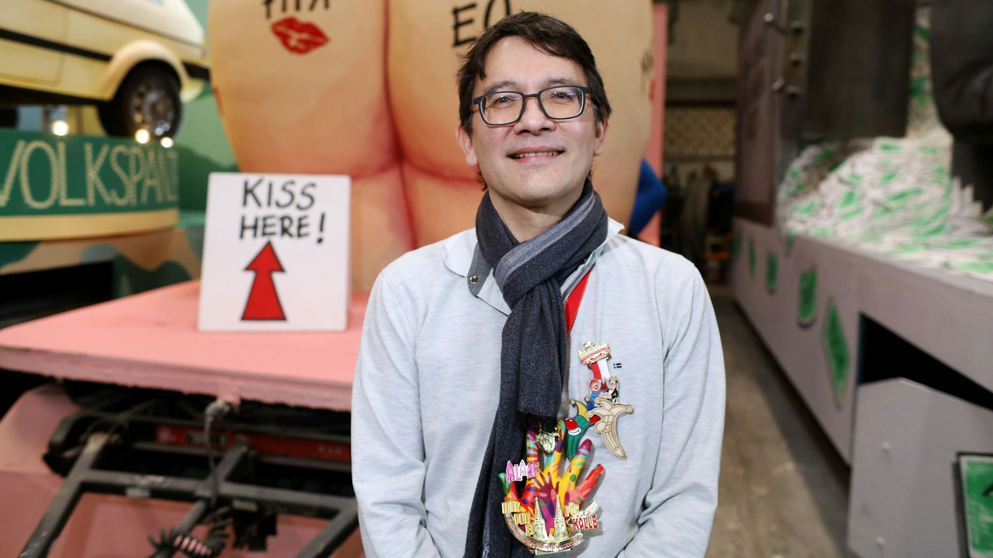 Zeichner Heiko Sakurai vor seinem Entwurf zum Trump-Karnevalswagen.