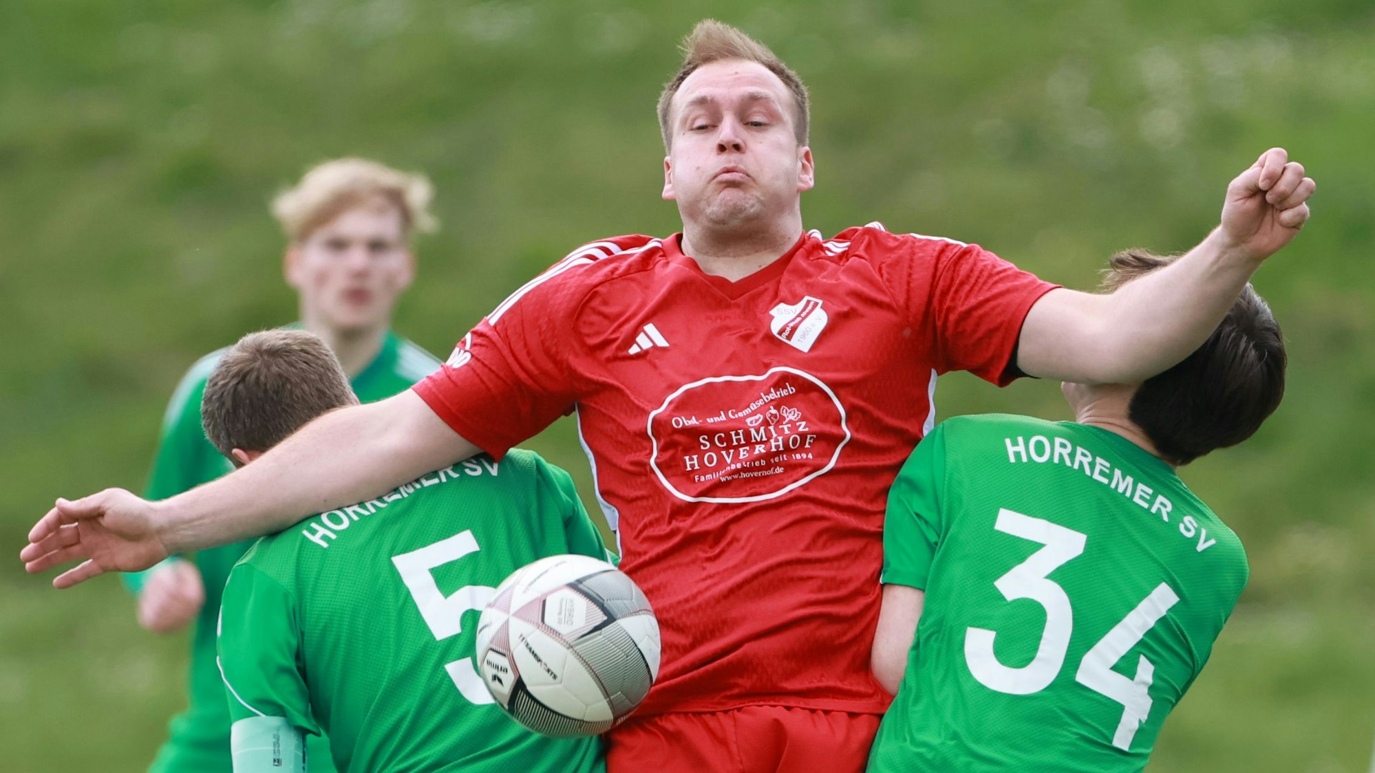 Das Bild zeigt einen Ahremer Fußballspieler, der eingekesselt von zwei Horremer Gegenspielern, den Ball zu behaupten versucht.