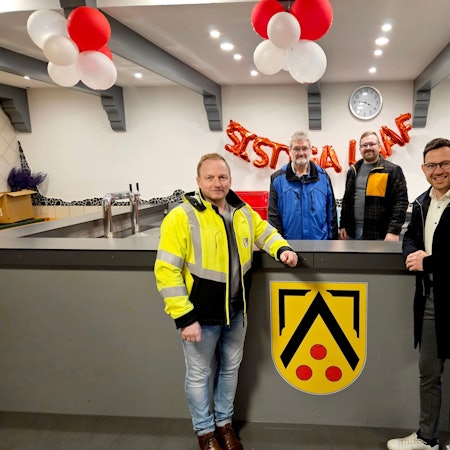 An der neuen Theke im Bürgerhaus in Kall-Sistig stehen vier Männer.