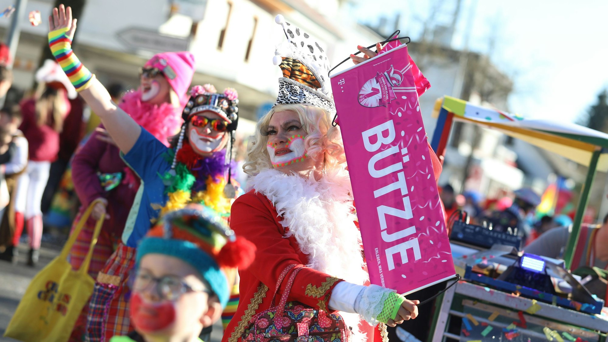 Eine Zugteilnehmerin hält ein Banner mit dem Wort „Bützje“ in der Hand.