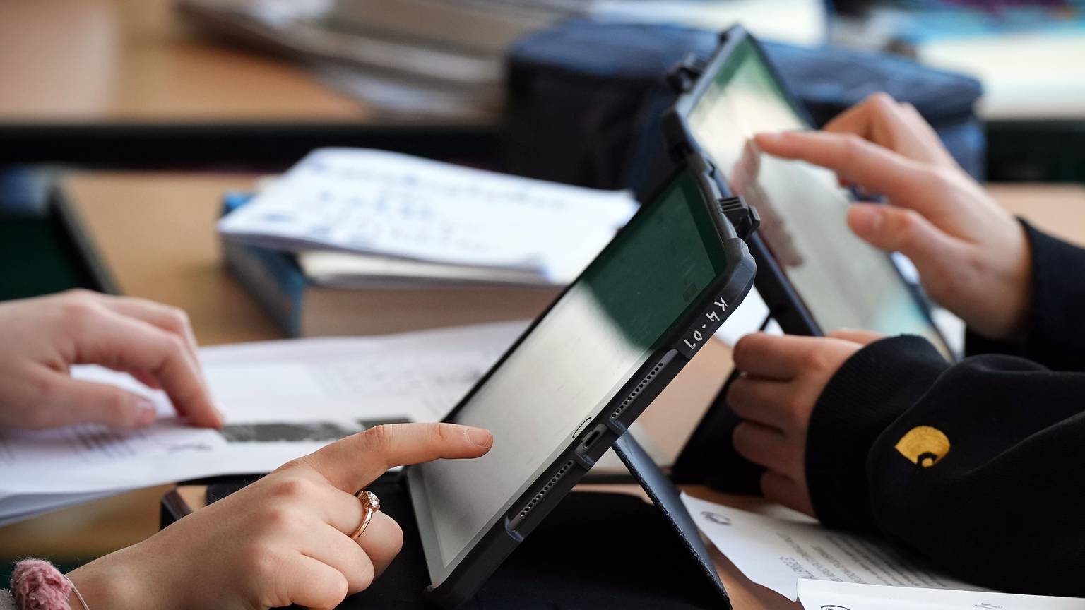 Schüler lösen Aufgaben im Schulunterricht an einem Tablet.
