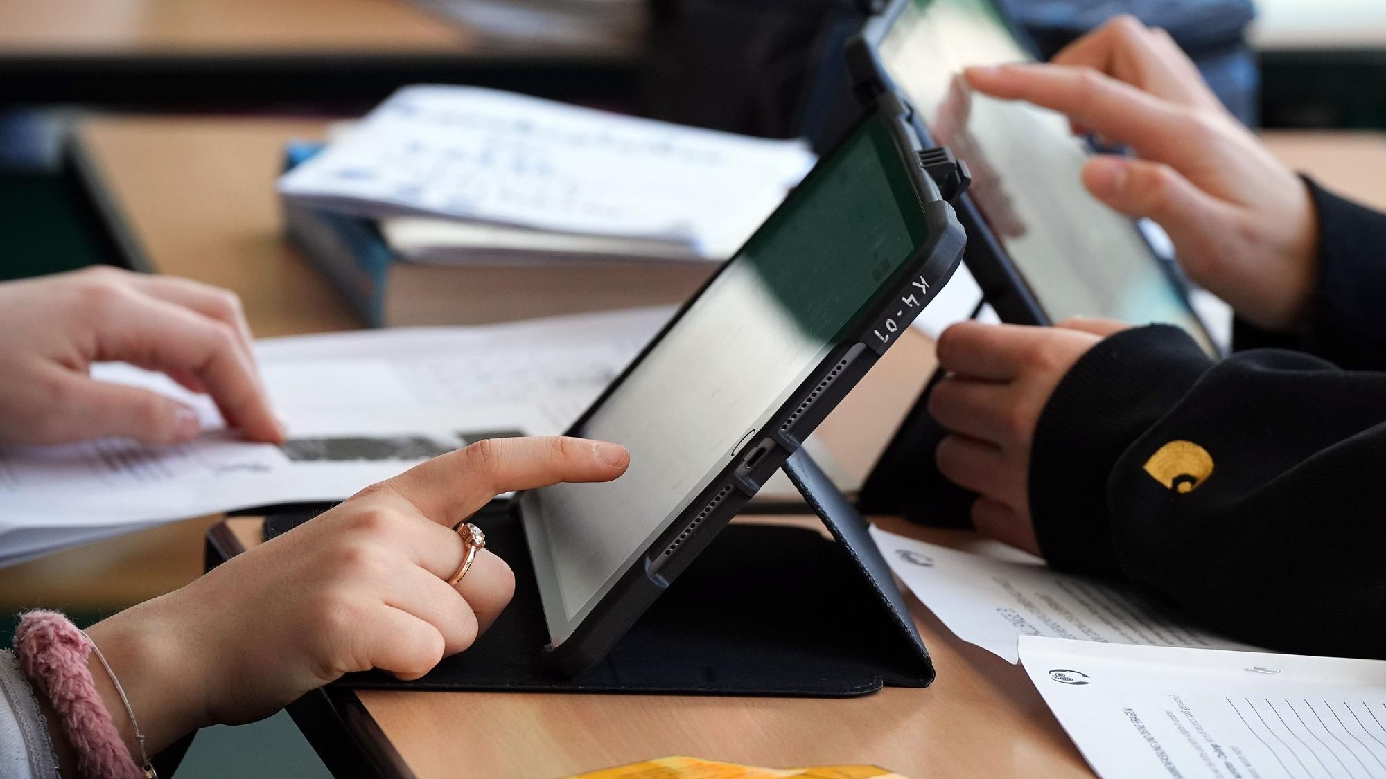 Schüler lösen Aufgaben im Schulunterricht an einem Tablet.