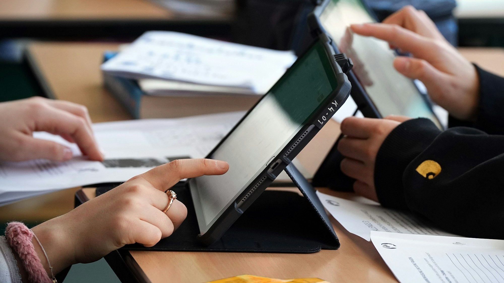 Schüler lösen Aufgaben im Schulunterricht an einem Tablet.