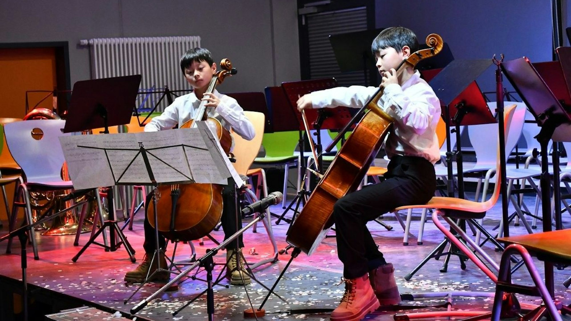 Zwei Jungs spielen Cello.