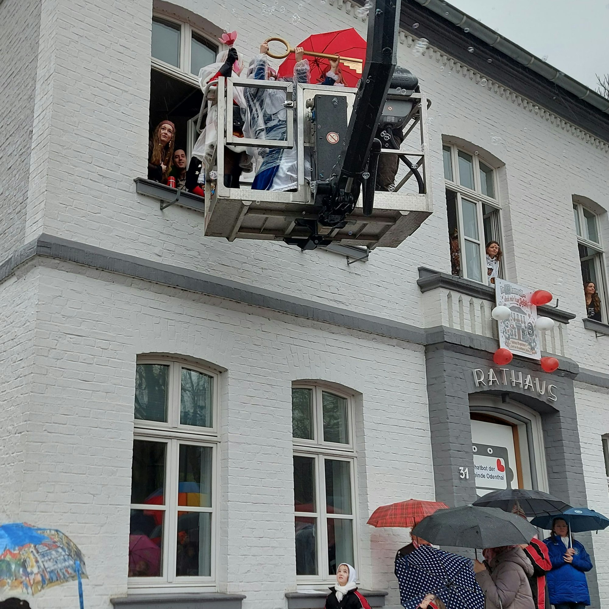 Ein Hubsteiger mit Menschen im Korb fährt an ein Fenster heran.
