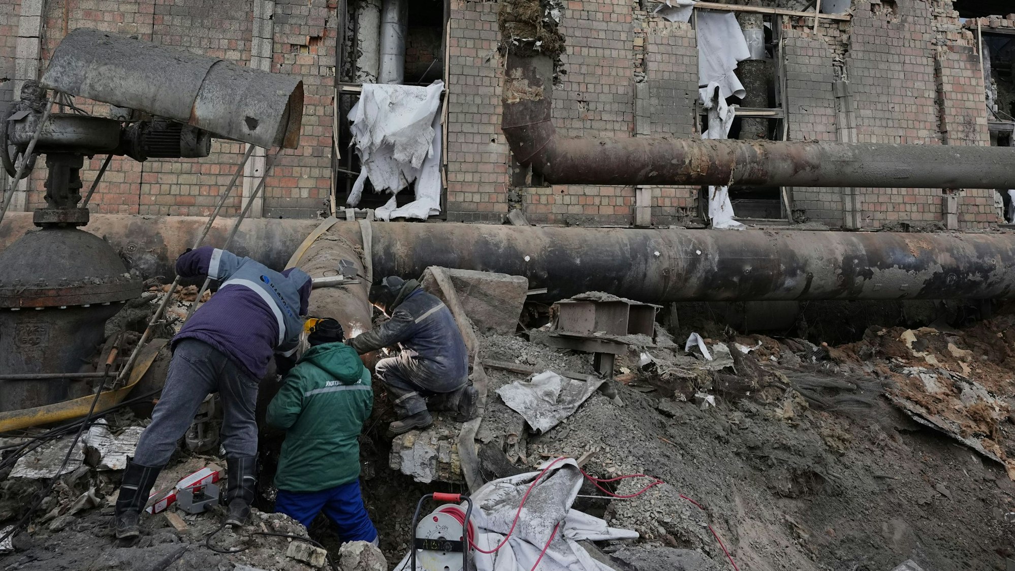 Arbeiter in Kiew beseitigen Schäden im Wärmekraftwerk Darnyzja nach einem russischen Angriff in Kiew.