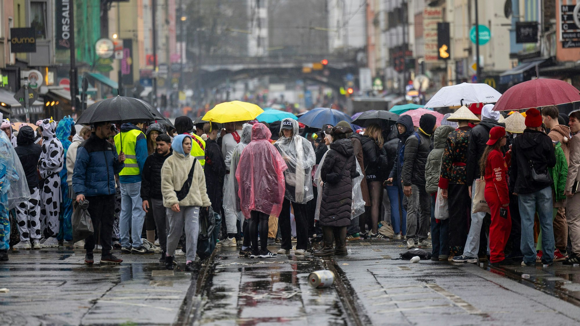 12.02.2026, Nordrhein-Westfalen, Köln: Karnevalisten feiern trotz Regen auf der Zülpicher Straße. Mit der Weiberfastnacht beginnt in den närrischen Hochburgen der Straßenkarneval. Foto: Thomas Banneyer/dpa +++ dpa-Bildfunk +++