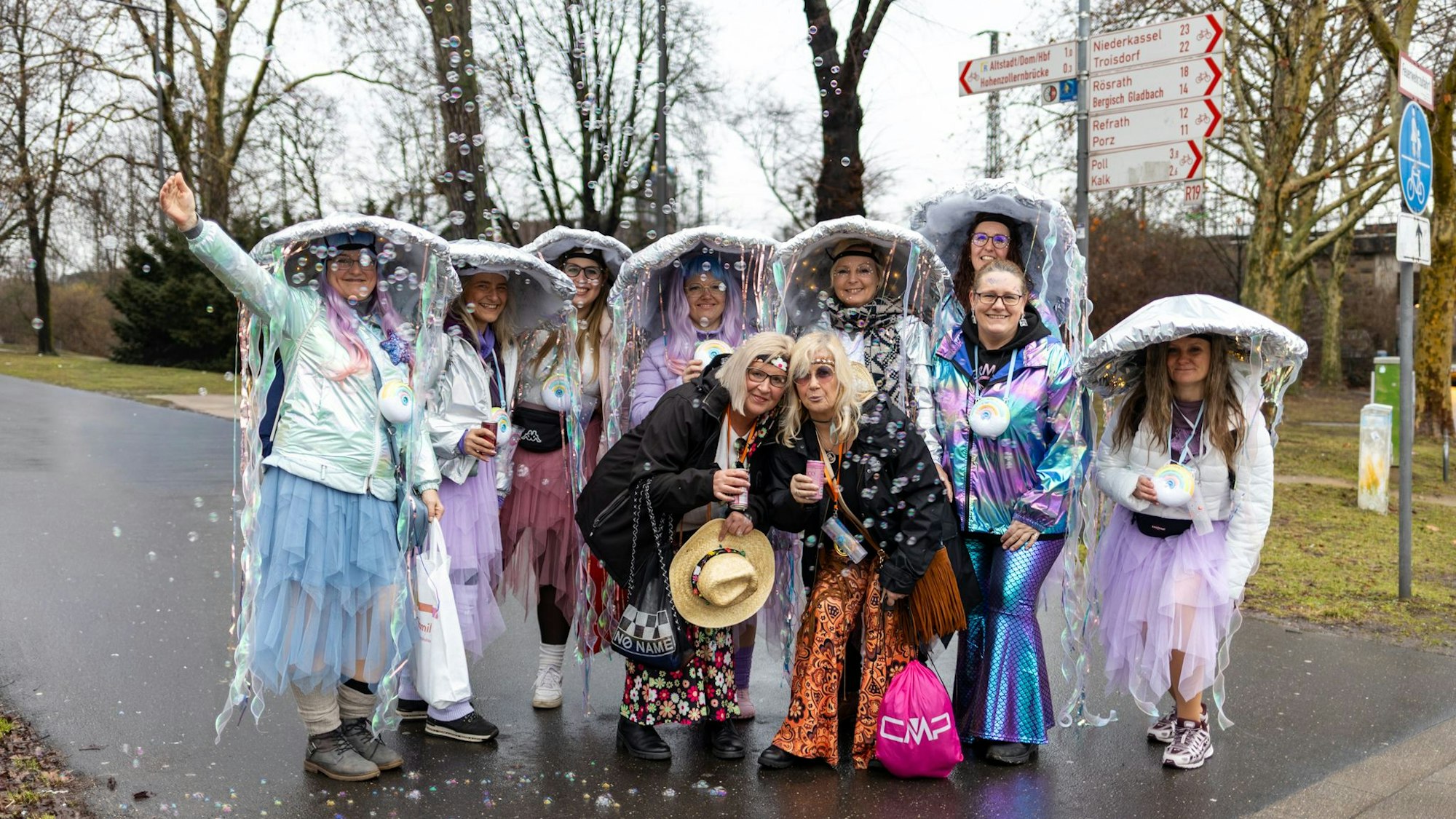 Eine Gruppe Frauen, verkleidet als Quallen und Hippies, jubelt in die Kamera.