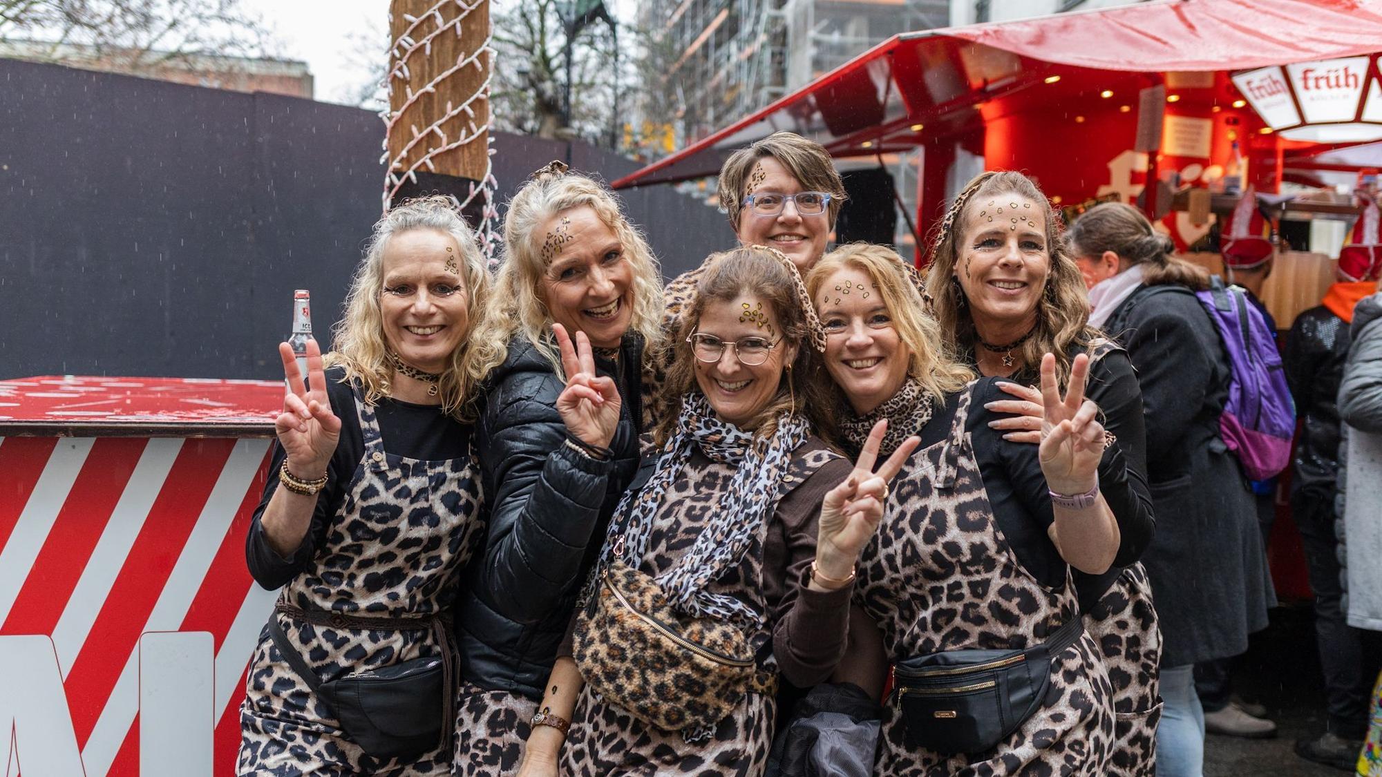 Sechs Frauen tragen einen Overall mit Leopardenmuster.