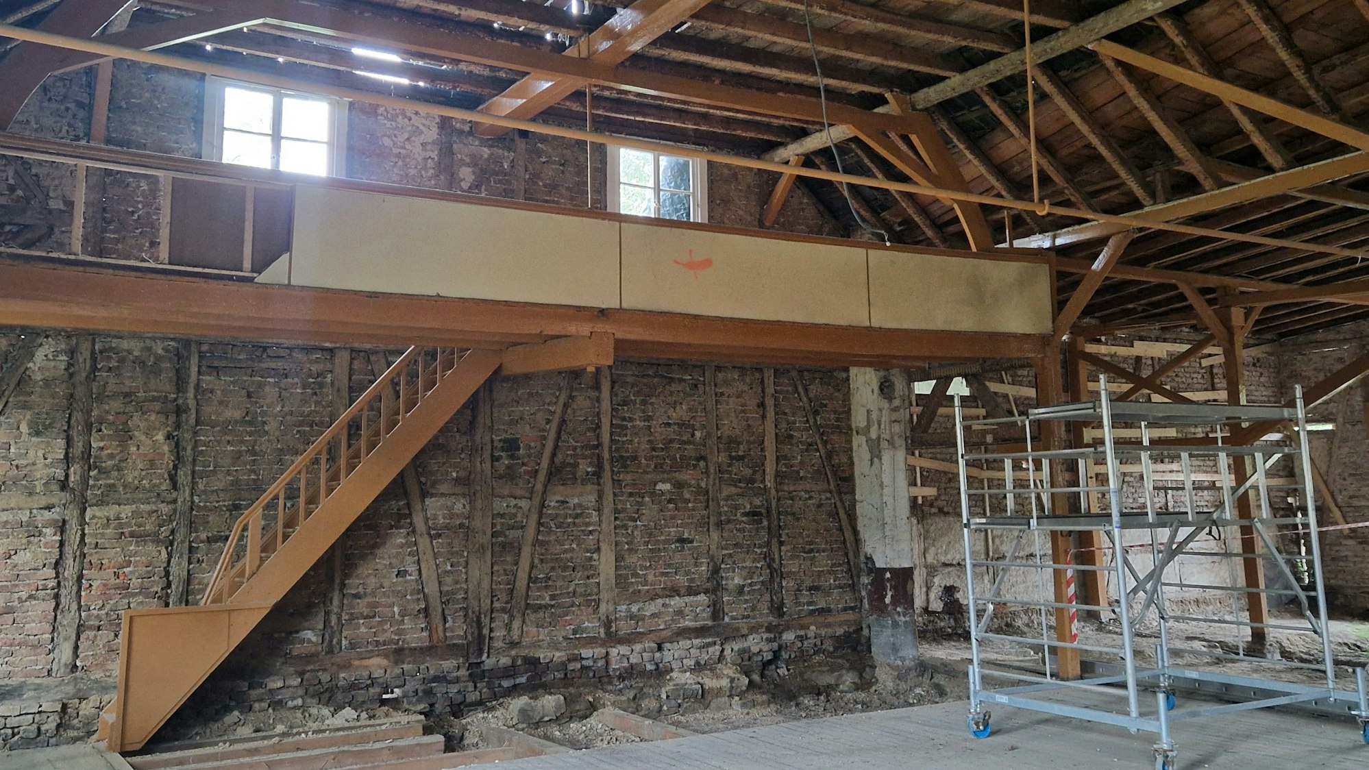 Zu sehen ist ein entkernter Saal, dessen Wände mit Fachwerk gebaut sind.