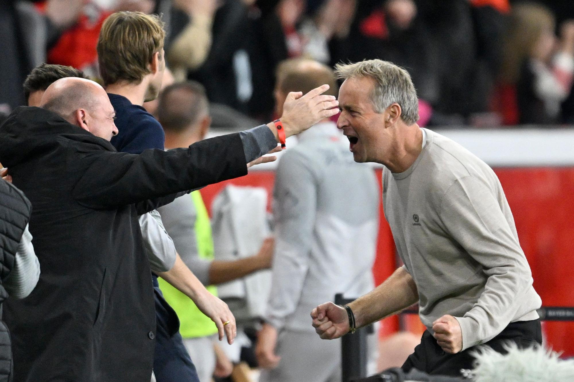 Bayer Leverkusen's Danish head coach Kasper Hjulmand (R) celebrates with Bayer Leverkusen's CEO Fernando Carro after the end of the German first division Bundesliga football match between Bayer 04 Leverkusen and Eintracht Frankfurt in Leverkusen, western Germany on September 12, 2025. (Photo by INA FASSBENDER / AFP) / DFL REGULATIONS PROHIBIT ANY USE OF PHOTOGRAPHS AS IMAGE SEQUENCES AND/OR QUASI-VIDEO
