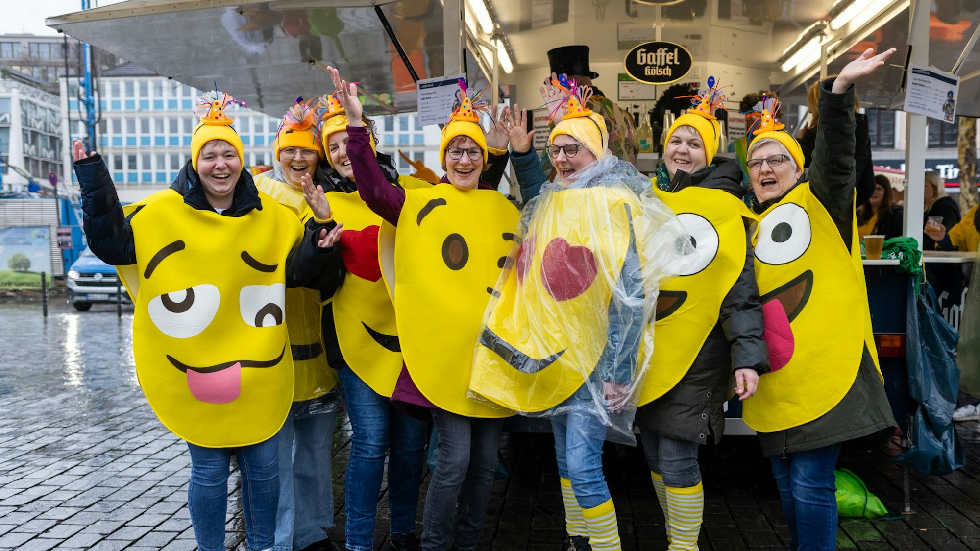 Sieben Frauen tragen große, gelbe Kreise mit Augen darauf.