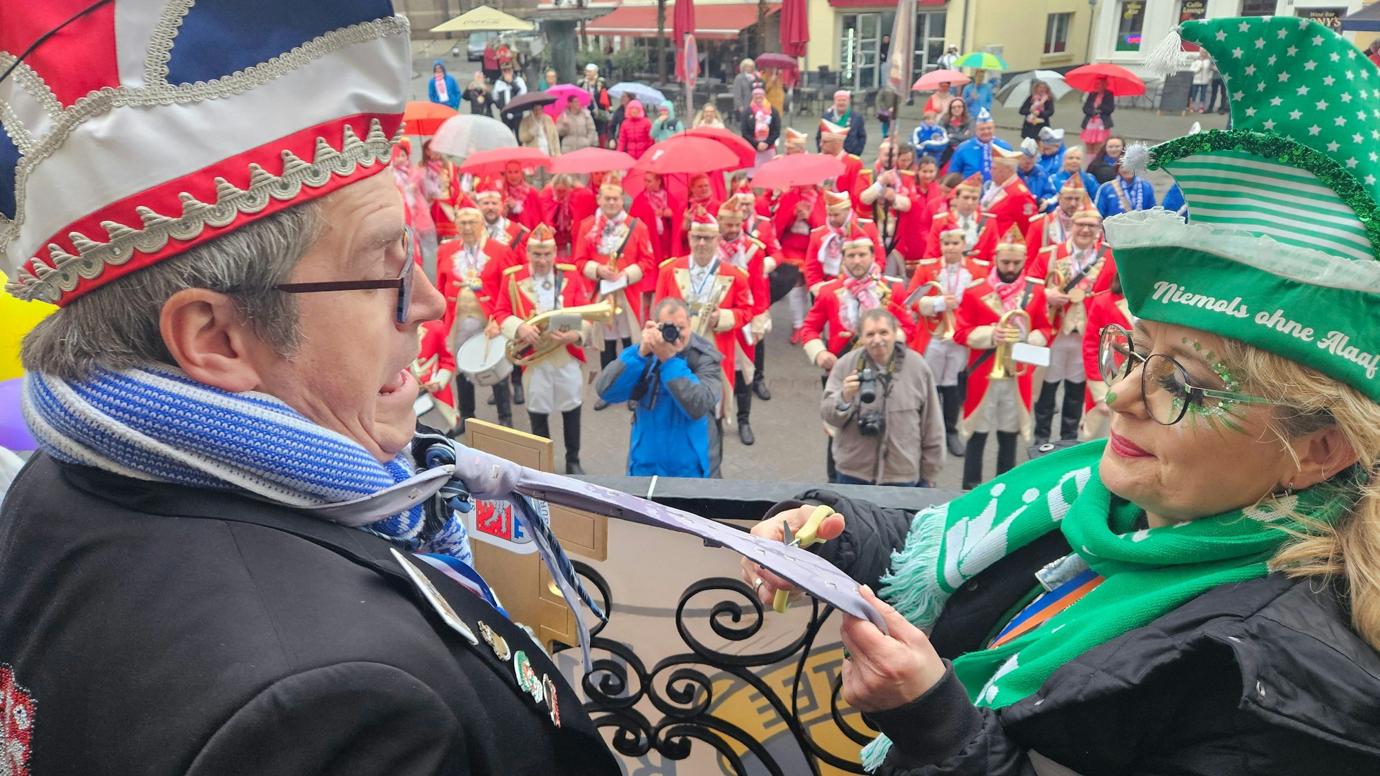 Barbara Sieger von der Katholischen Frauengemeinschaft schneidet Bedburgs Bürgermeister Sascha Solbach den Schlips ab.