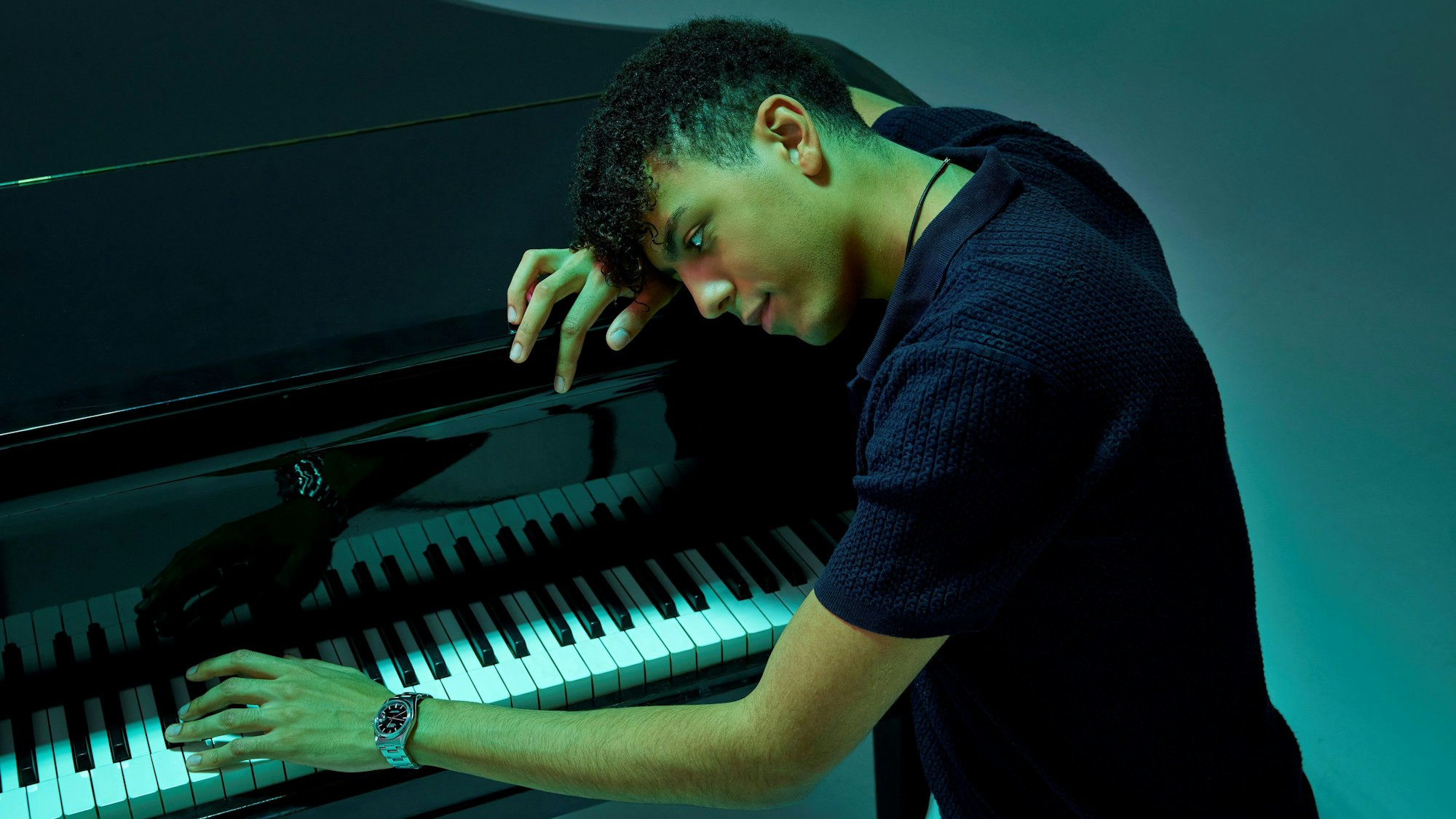 Ein Mann neigt sich über ein Klavier.