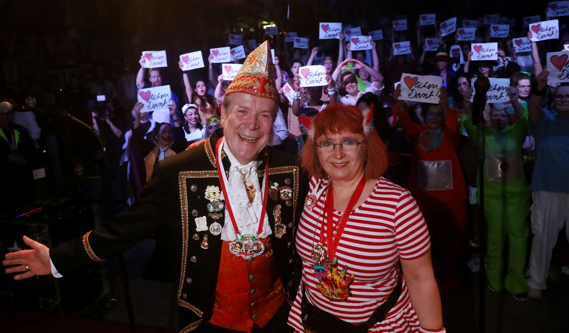 Angela Wotzlaw verkleidet mit einem rot-weißen Ringelkleid und zwei roten Doppelhörnchen auf dem Kopf. Neben ihr Christoph Kuckelkorn