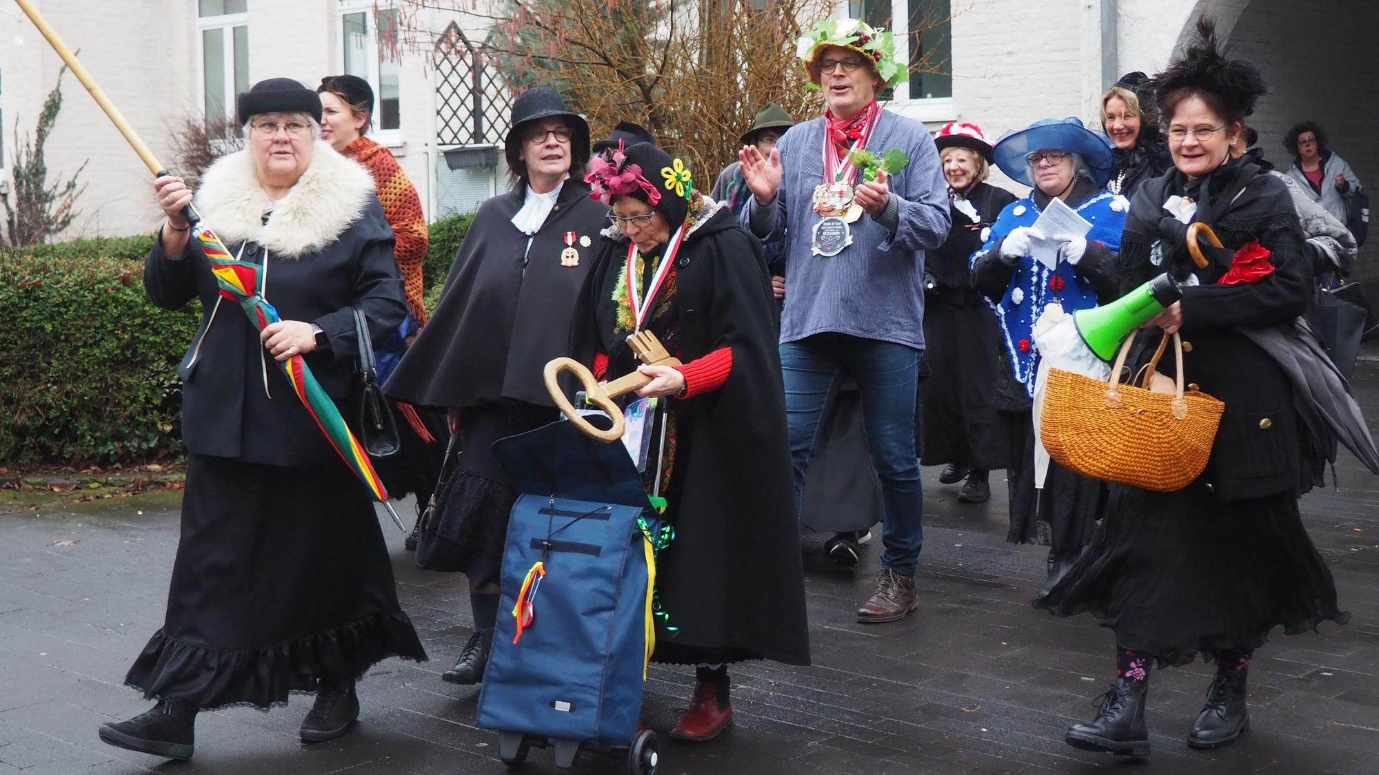 Die Möhnen haben Bürgermeister Hürtgen in ihre Mitte genommen auf dem Weg zum Feiern.