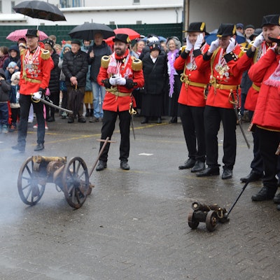 Die Kanone der Prinzengarde qualmt. Zuschauer und Prinzengardisten halten sich die Ohren zu.