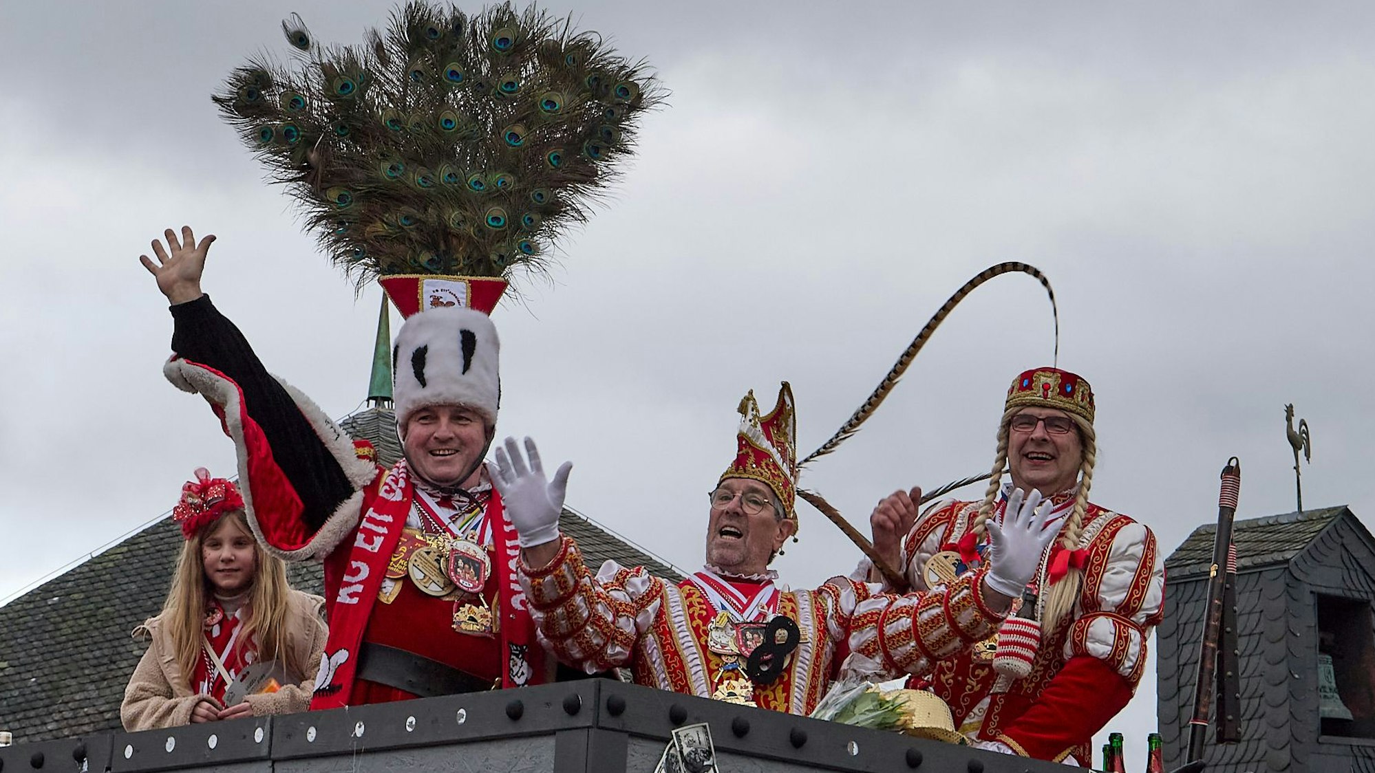 Das Ettelscheider Dreigestirn grüßt fröhlich vom Wagen.