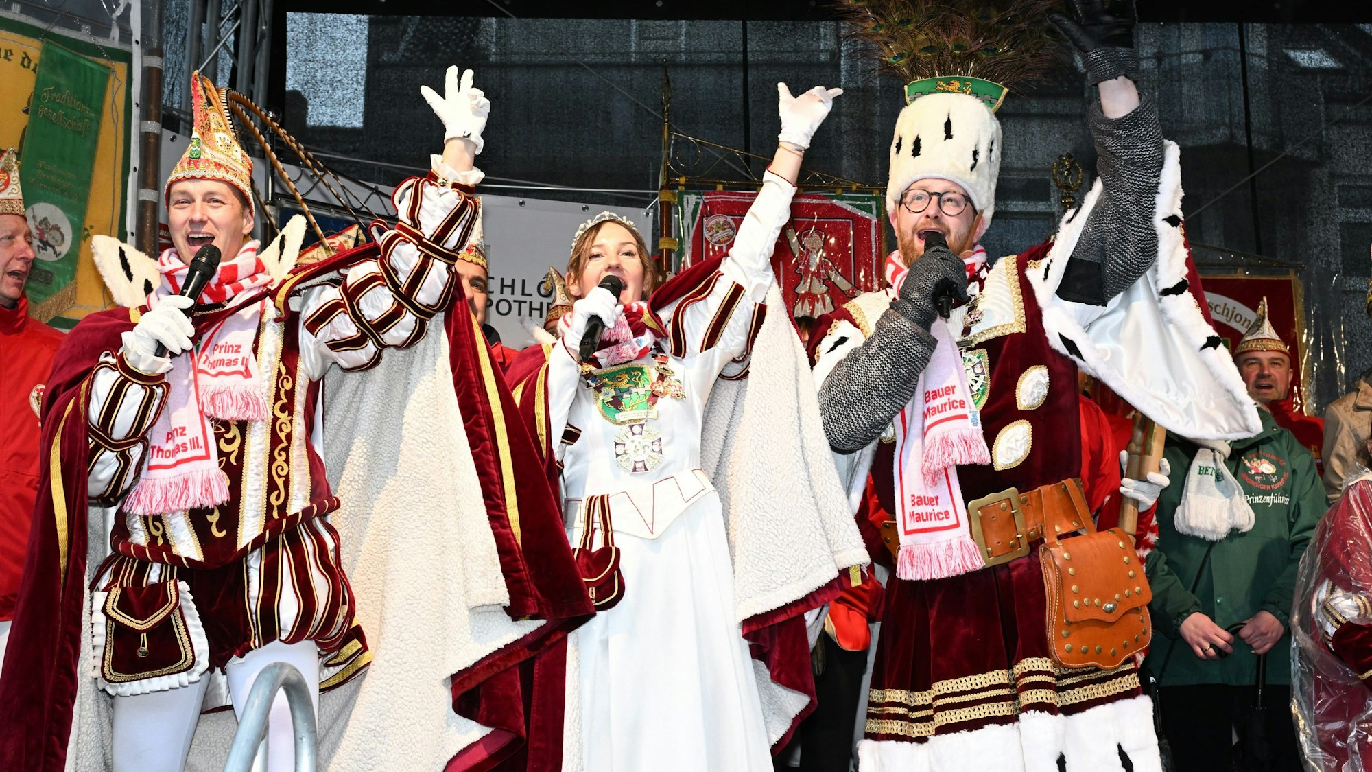 Prinz, Jungfrau und Bauer halten sich je ein Miko vor den Mund und haben den linken Arm erhoben.