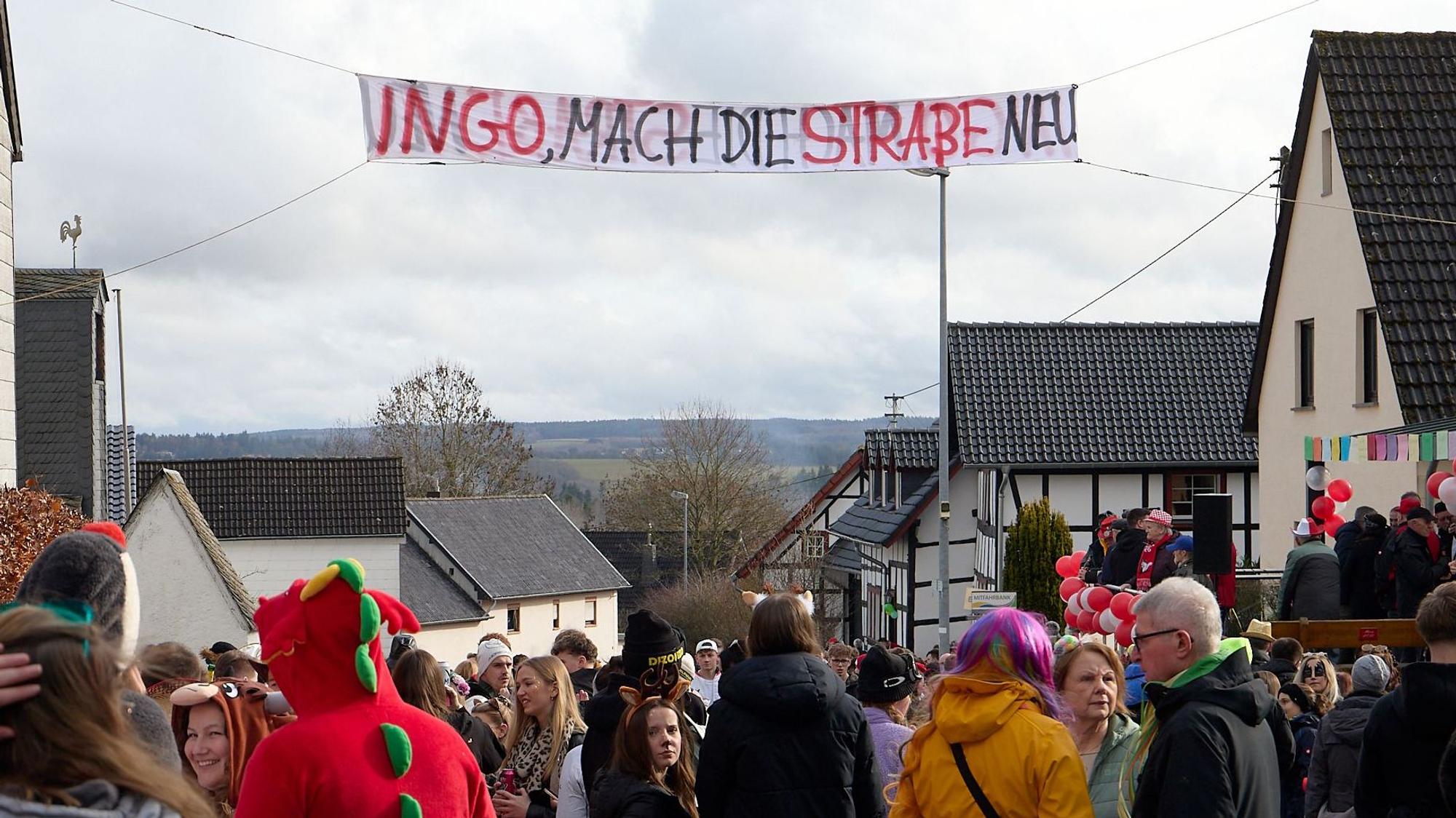 Auf einem Banner, das über der Straße hing, stand: „Ingo, mach' die Straße neu“.