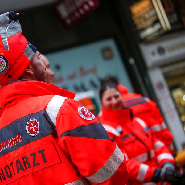 Ein Notarzt der Johanniter hat eine Narrenkappe auf.