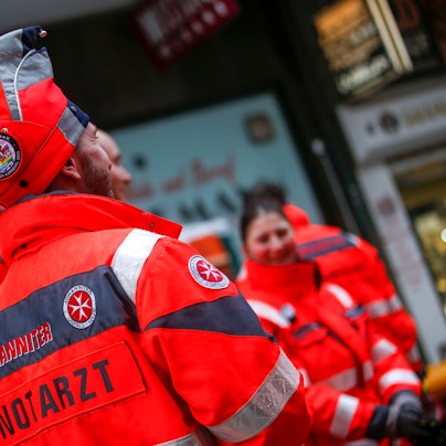 Ein Notarzt der Johanniter hat eine Narrenkappe auf.