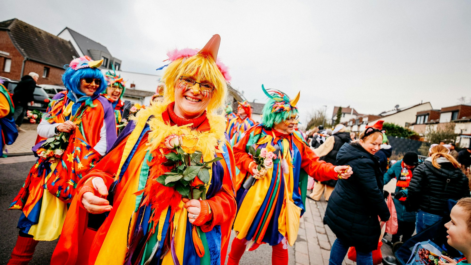 Farbenfroh kostümierte Karnevalisten auf den Straßen Hitdorfs.