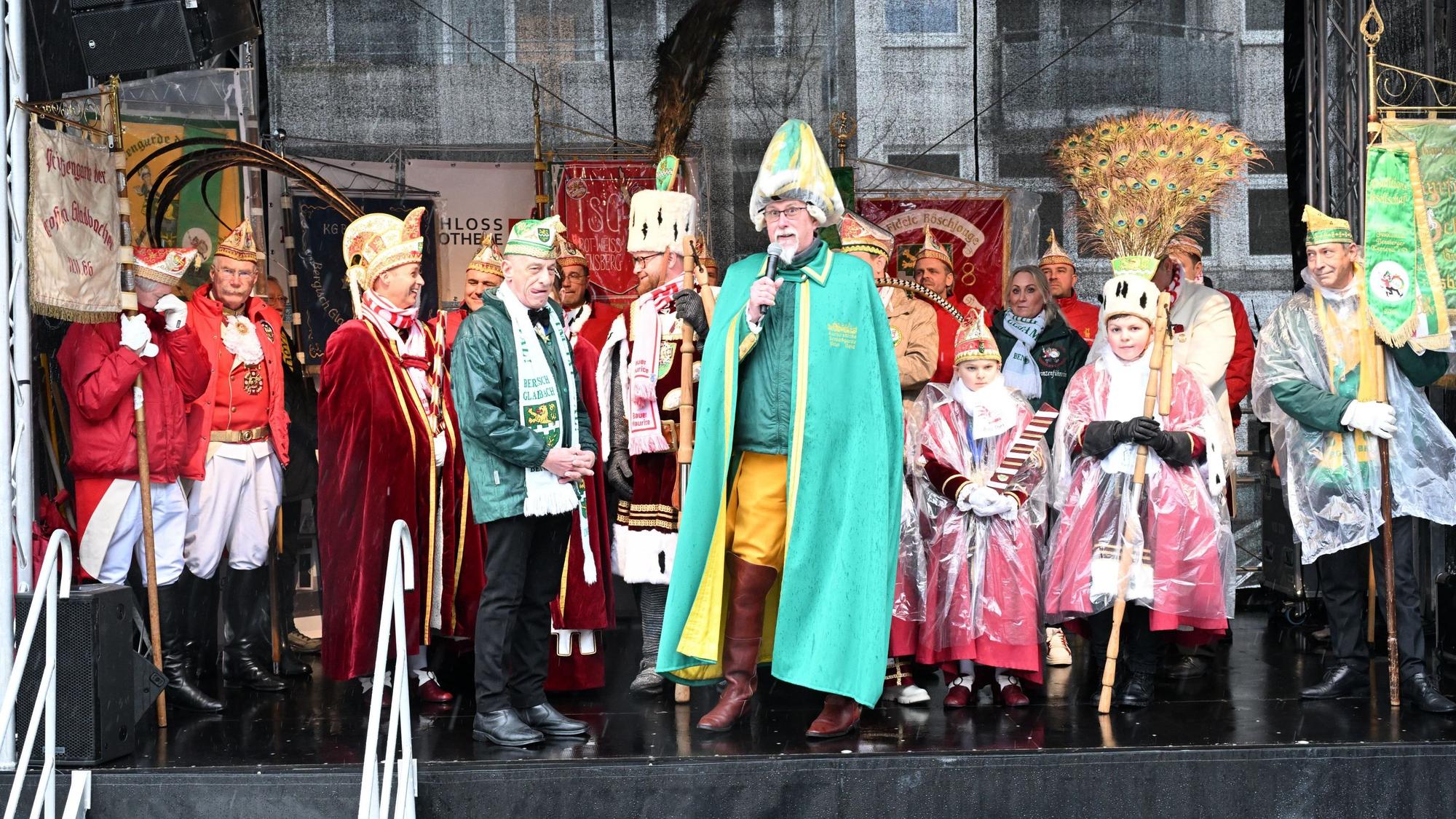 Viele Kostümierte auf einer Bühne. In der Mitte ein Kommandant mit Federhelm.