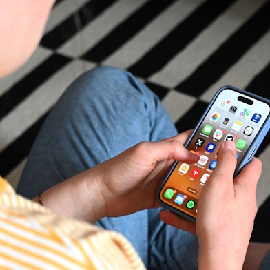 SYMBOLBILD – 17.05.2025, Sachsen, Leipzig: Eine Jugendliche sitzt auf dem Boden und nutzt ein Smartphone – auf dem Display sind verschiedene Apps zu sehen. (zu dpa: „Linke und SPD gegen ein Social-Media-Verbot für Jugendliche“) Foto: Elisa Schu/dpa +++ dpa-Bildfunk +++