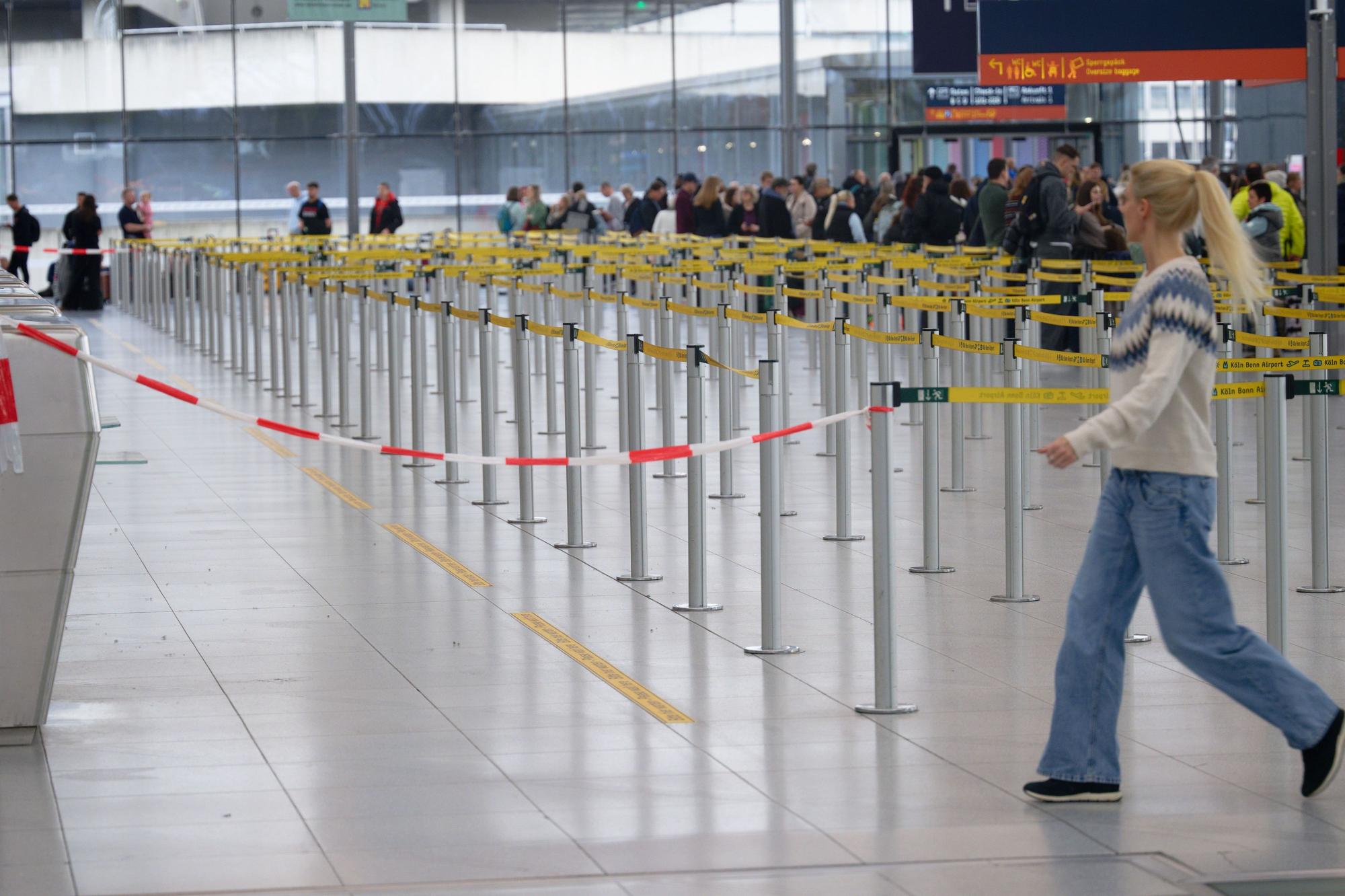 Eine Frau läuft durch die beinahe leere Halle des Flughafens Köln/Bonn. Aufgrund eines Sicherheitsvorfalls war der Flugbetrieb auf dem Flughafen Köln/Bonn zeitweise weitgehend eingestelltworden.