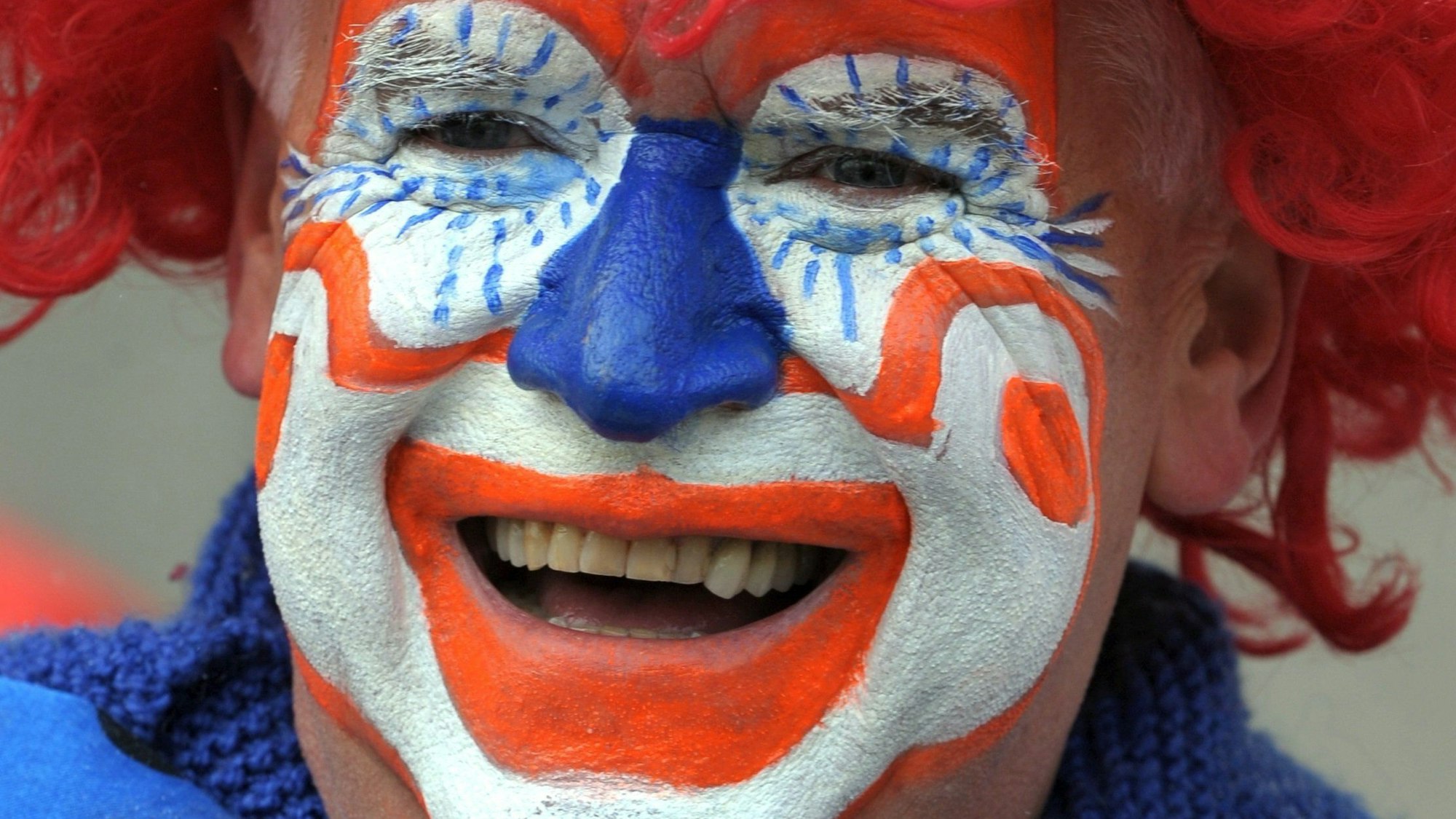 Das Foto zeigt einen lachenden Clown im Karneval.