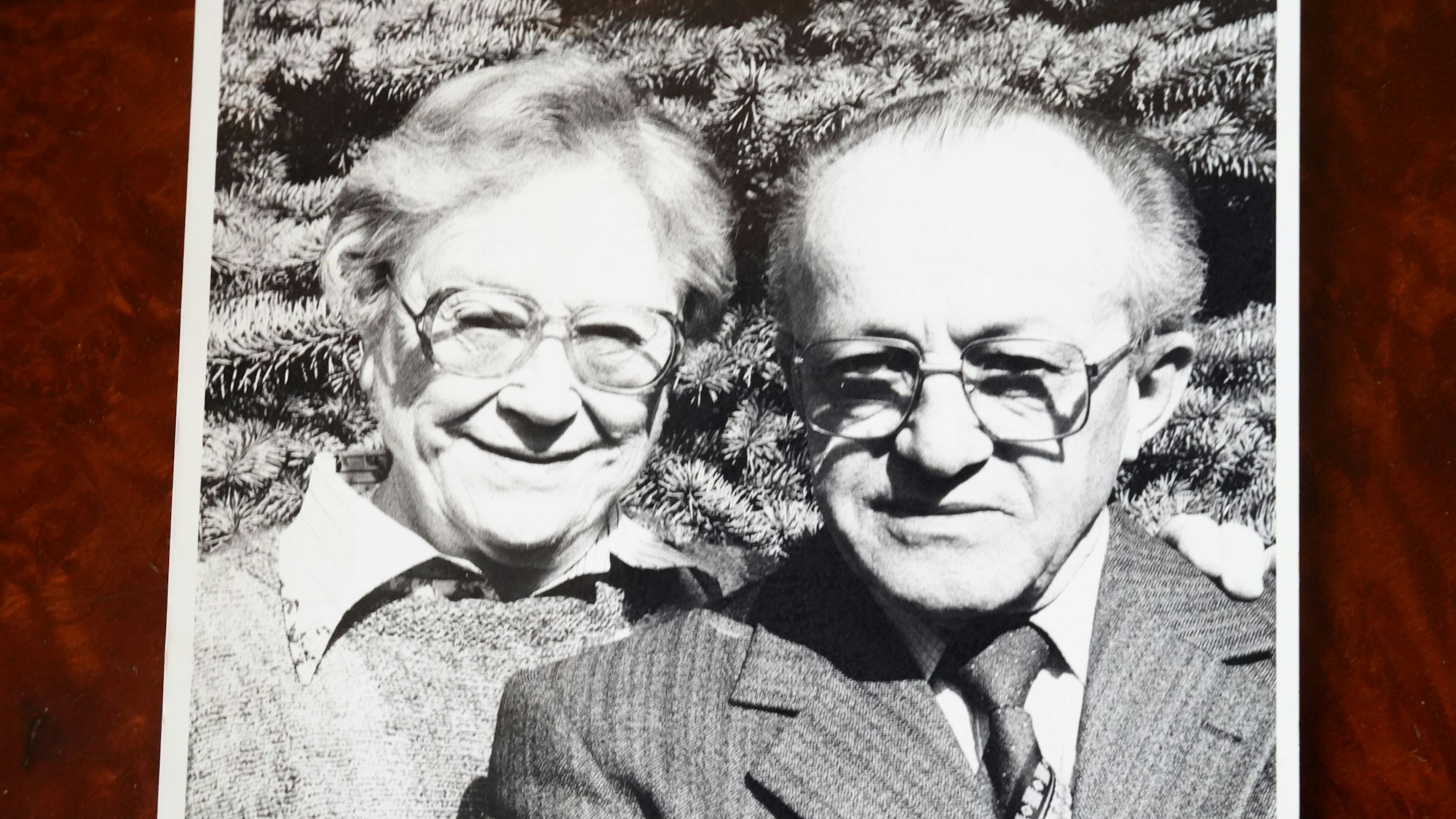 Das Bild zeigt eine schwarz-weiß Fotografie von Franz Bauer mit seiner Frau Hilda Bauer. Er trägt eine eckige Brille und einen Anzug mit Krawatte.