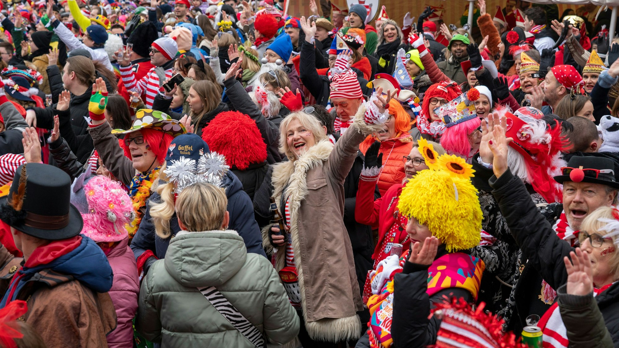 Tausende Menschen feiern beim Funken-Biwak auf dem Neumarkt bei leichtem Schneefall.