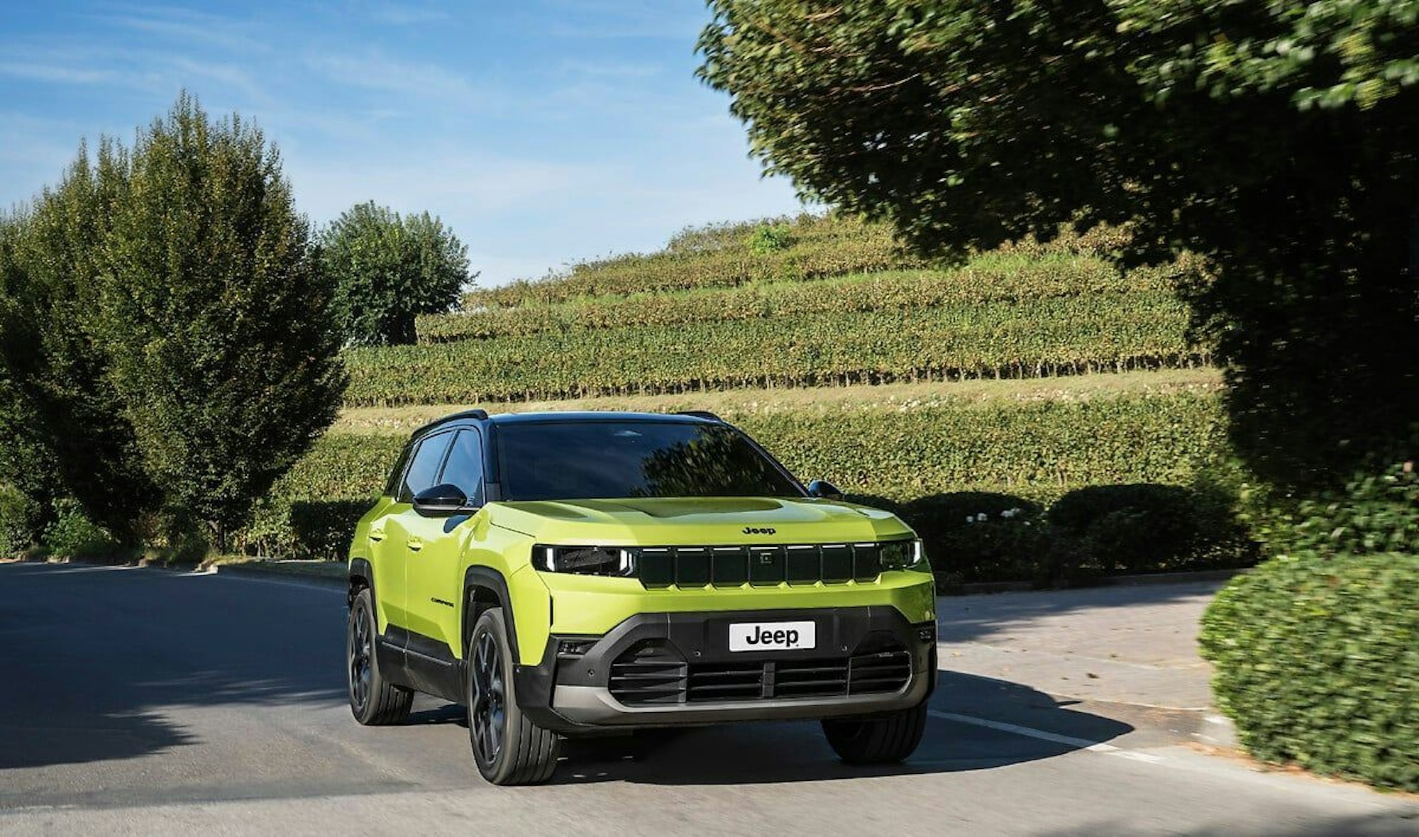 Ein hellgrüner Jeep Compass Facelift in einer Außenaufnahme.