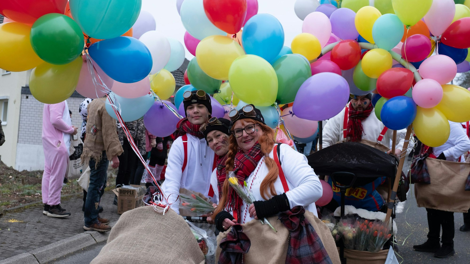 Das Foto zeigt Jecke mit bunten Ballons