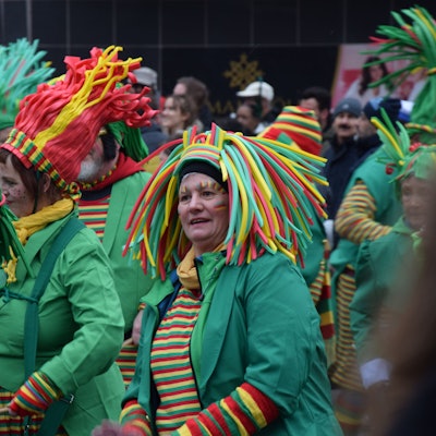 Frauen in Ringelshirts mit bunten Hüten laufen im Zoch mit.
