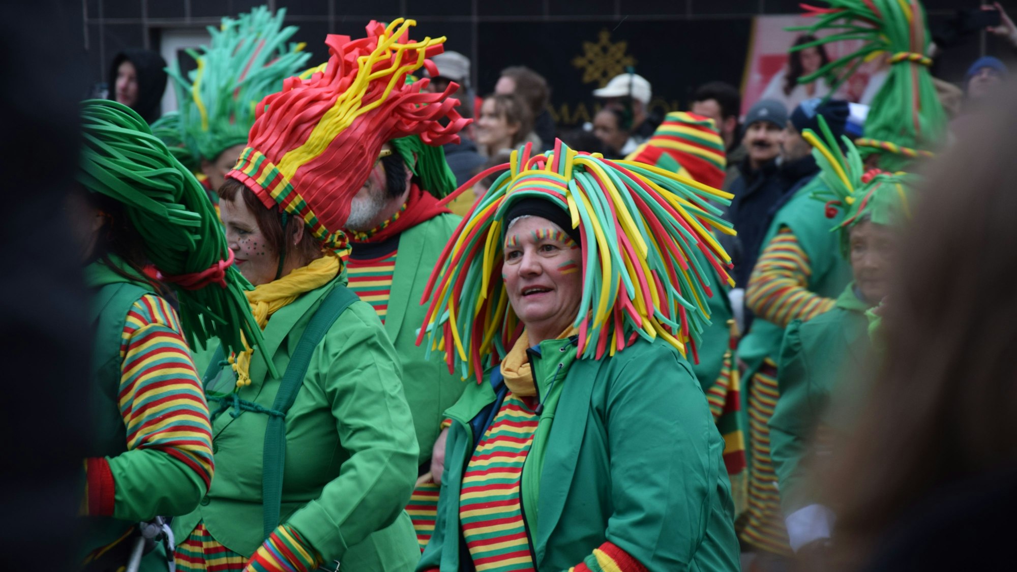 Frauen in Ringelshirts mit bunten Hüten laufen im Zoch mit.