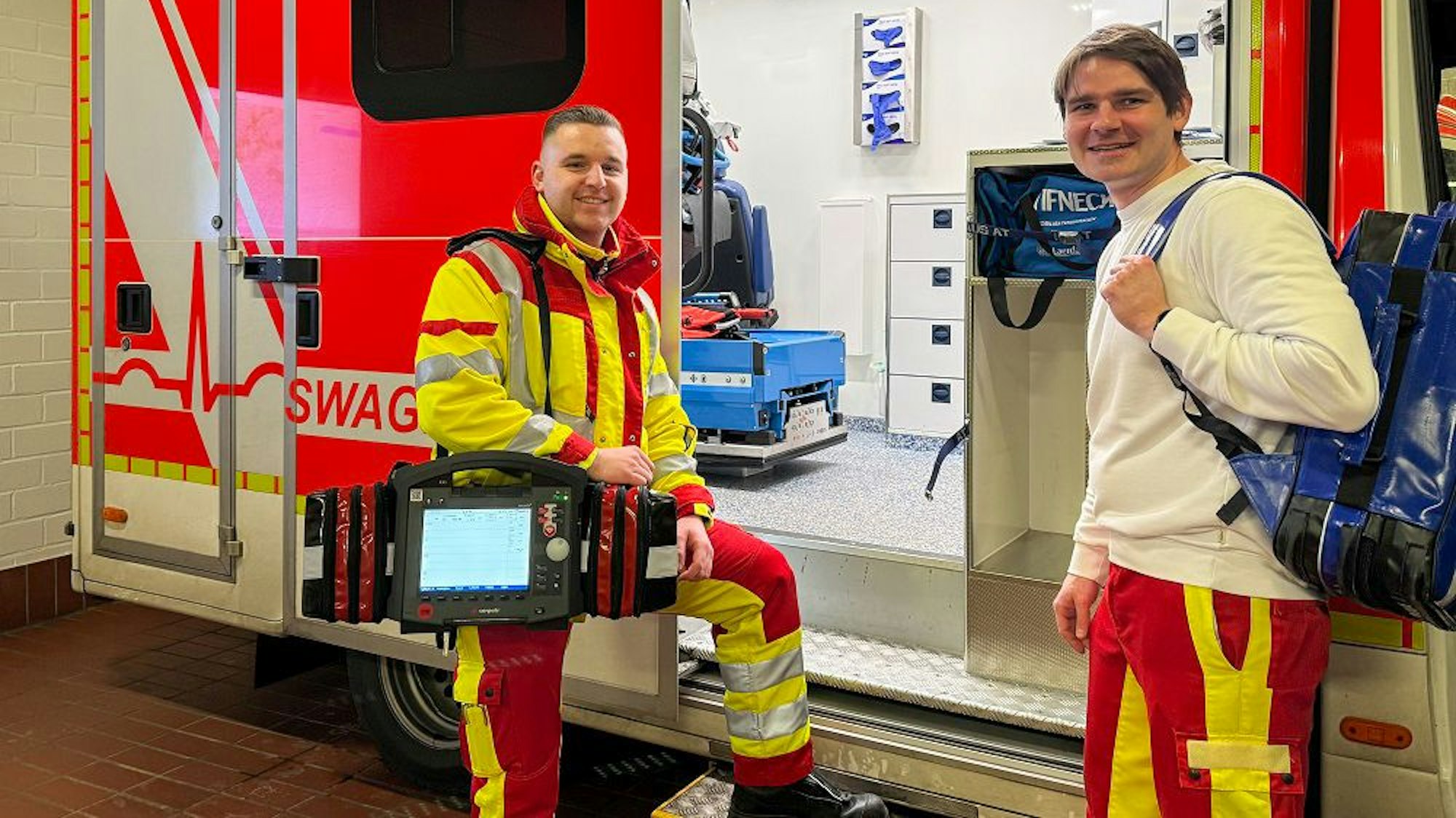 Das Foto zeigt zwei Männer vor einem Rettungswagen.