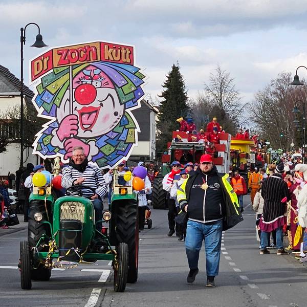 Auf einem Traktor ist ein Schild befestigt, das einen Clown zeigt.