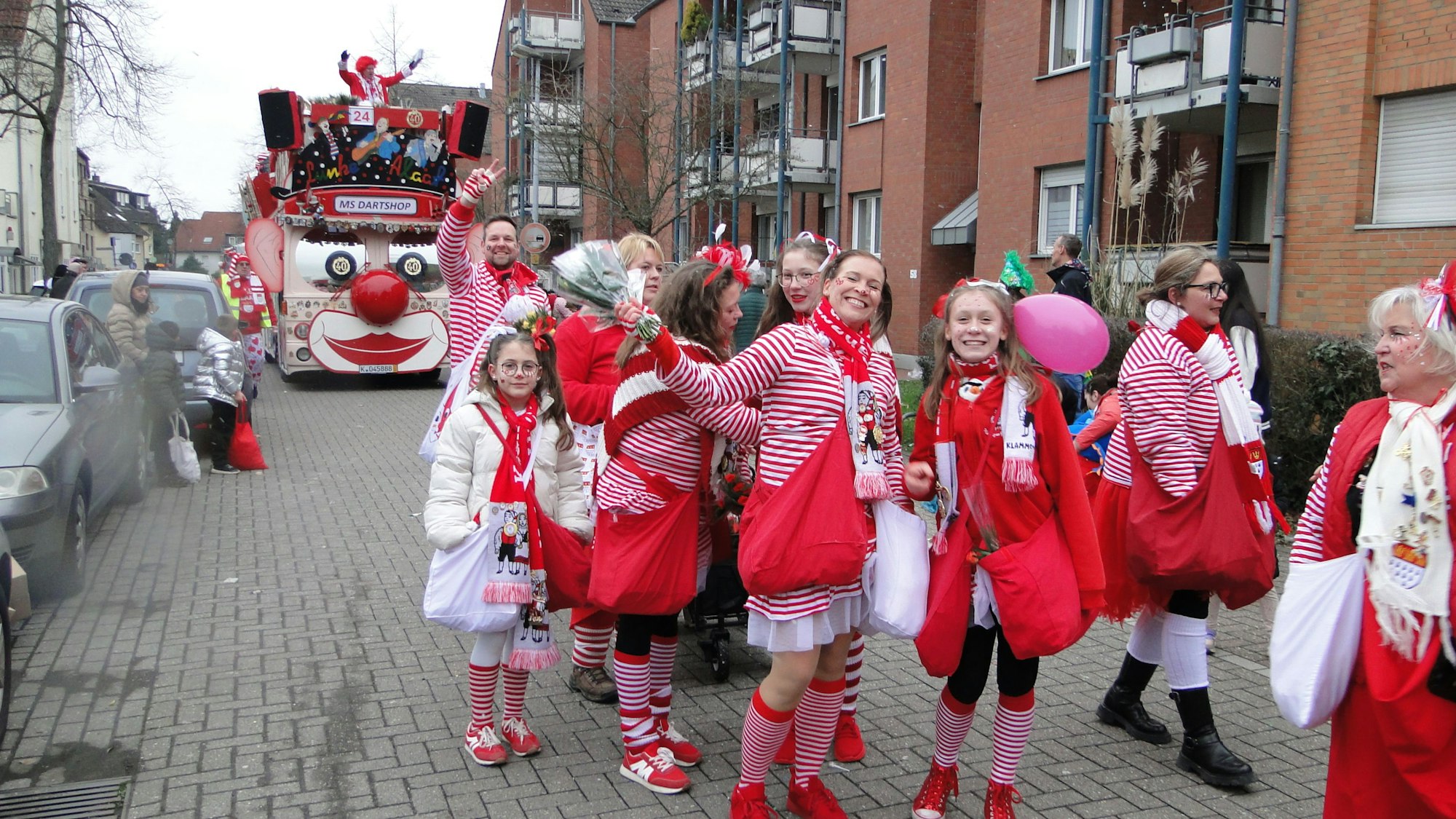 Eine Gruppe Erwachsene und Kinder sind in Rot-Weiß unterwegs.