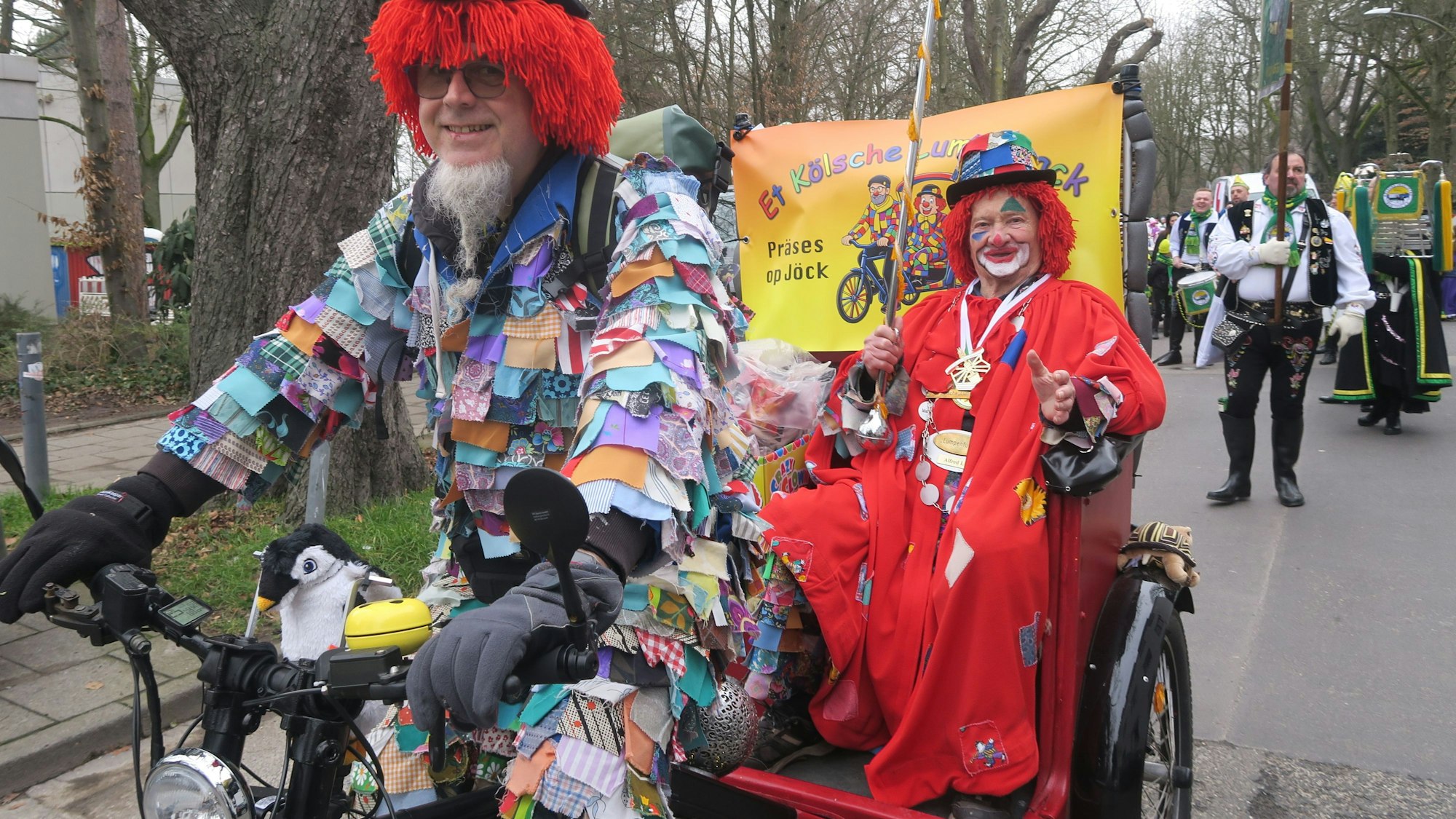 Auf einem Fahrrad sitzen zwei Jecke.
